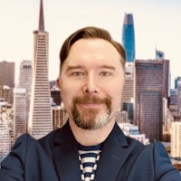 a man with a beard in front of a city skyline